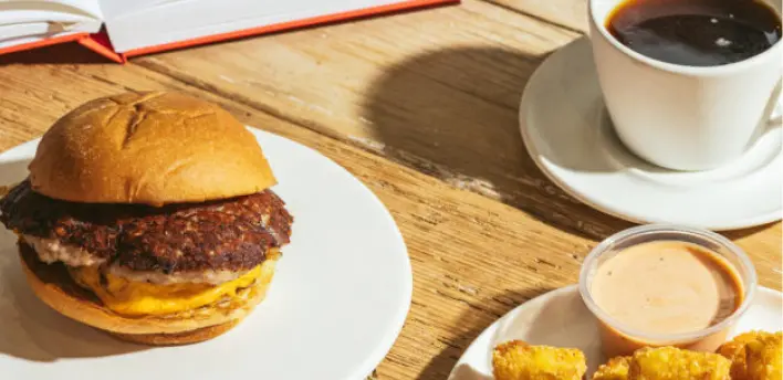 A Shake Shack burget with coffee and crispy chicken bites